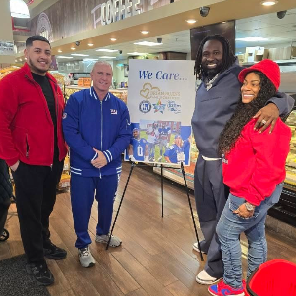 Smiling group of four standing by a We Care poster.