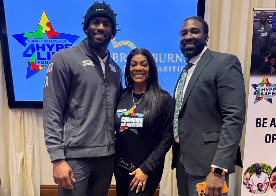 Brian, Stanley, and their sister smiling in front of a charity event backdrop.