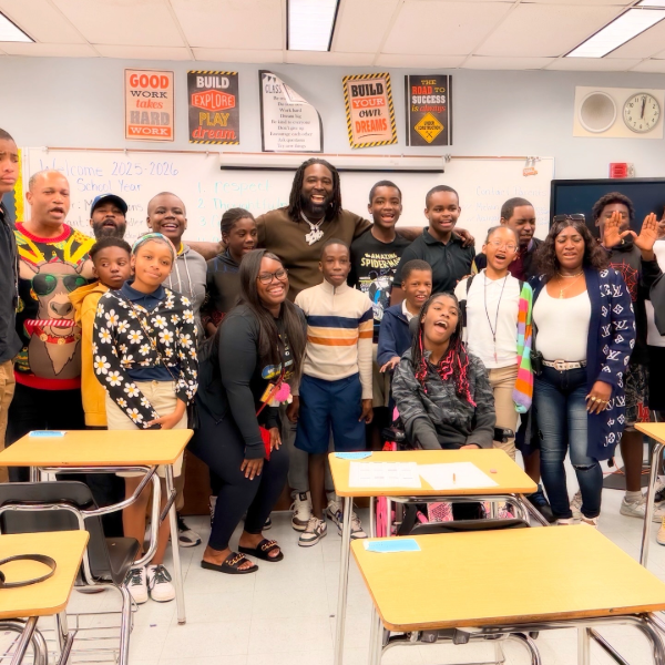 Smiling people in a classroom with motivational posters.